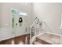 Bright foyer with hardwood floors, decorative front door with sidelights, stairs, and high ceilings at 5818 Downfield Wood Dr, Charlotte, NC 28269