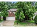 Charming brick two-story home featuring a two-car garage and mature trees at 5818 Downfield Wood Dr, Charlotte, NC 28269