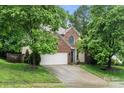 Charming brick two-story home featuring a two-car garage and mature trees at 5818 Downfield Wood Dr, Charlotte, NC 28269