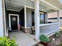 Inviting front porch with rocking chair, stone accents, gray siding, and patriotic decorations for added charm at 6266 Swanport Rd, Lancaster, SC 29720