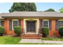 Close up of double front doors with wreaths and manicured shrubs and brick steps at 6301 Cherrycrest Ln, Charlotte, NC 28217