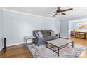 Cozy living room with soft blue walls, a ceiling fan, and hardwood floors at 6301 Cherrycrest Ln, Charlotte, NC 28217