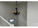Staircase with black chandelier and view of the front yard through a glass door at 6839 Wagon Oak Rd, Charlotte, NC 28212