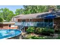 Backyard view featuring an above-ground pool, wooden deck, and a brick home exterior at 701 5Th Ne Ave, Conover, NC 28613