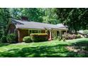Well-kept front yard of a brick home, showcasing vibrant green grass and mature shrubbery at 701 5Th Ne Ave, Conover, NC 28613