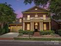 A brick two-story home with attached garage, manicured lawn, and covered entrance at dusk at 7011 Conservatory Ln, Charlotte, NC 28210