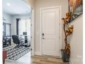 Inviting entryway leads to a home office space with a glass desk, patterned rug, and stylish decor at 8008 Brookbank Dr, Charlotte, NC 28269