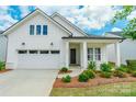 Charming white exterior of a single-story home, with a manicured front lawn and attached two-car garage at 8008 Brookbank Dr, Charlotte, NC 28269