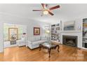 Elegant living room showcasing hardwood floors, a fireplace with built-in shelving, and comfortable seating at 9513 Tresanton Dr, Charlotte, NC 28210