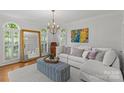 Bright living room featuring a sectional sofa, statement mirror, and large windows providing ample natural light at 9513 Tresanton Dr, Charlotte, NC 28210