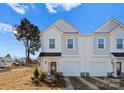 A view of a modern white duplex with a private driveway showcasing curb appeal and architectural design at 9713 Misenheimer Rd # 4A, Charlotte, NC 28215