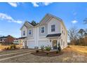 New townhome construction with attached garages, landscaped front yards, and attractive architectural details on a sunny day at 9715 Misenheimer Rd # 4B, Charlotte, NC 28215