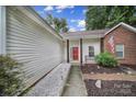 Inviting front porch with a bright red door, American flag, and a cozy bench at 1021 Stinson Glen Ln, Charlotte, NC 28214