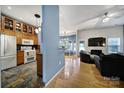 Open-concept living space with kitchen view, dining area, hardwood floors, and modern decor at 1021 Stinson Glen Ln, Charlotte, NC 28214