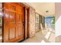 Close-up of the home's inviting front porch with rocking chairs, a wood door and brick facade at 11224 Warfield Ave, Huntersville, NC 28078