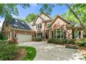 Beautiful two-story brick home with an attached garage, black shutters, and manicured landscaping at 11510 Pine Valley Club Dr, Charlotte, NC 28277