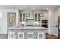 Modern kitchen boasts an island with bar seating and stylish pendant lighting fixtures at 11913 Casabella Dr, Huntersville, NC 28078