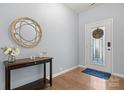 Bright foyer featuring hardwood floors, decorative mirror, and elegant entry door with glass paneling at 1221 Brookcrest Ln, Fort Mill, SC 29708