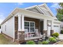 Inviting covered front porch with rocking chairs and stone accents, offering a cozy outdoor space at 1221 Brookcrest Ln, Fort Mill, SC 29708