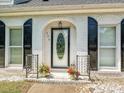 Close-up of a decorative front door with brick surround and flowering plants at 208 Armstrong Dr, Belmont, NC 28012