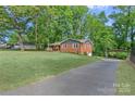 Spacious home with a long driveway, lush lawn, and mature trees, offering a serene setting at 2113 Woodlawn St, Kannapolis, NC 28083