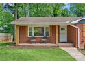 Inviting front porch with brick facade, wooden pillars and charming chairs at 2113 Woodlawn St, Kannapolis, NC 28083