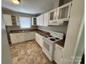 Bright kitchen with neutral walls, white cabinets, granite counters, and white appliances at 2434 Columbus Cir, Charlotte, NC 28208