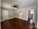 Open living room features hardwood floors, neutral walls, and a ceiling fan light fixture at 2434 Columbus Cir, Charlotte, NC 28208
