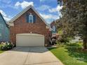 Brick two-story home showing the garage, front lawn, driveway and blue shutters at 2825 Redfield Dr, Charlotte, NC 28270