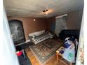 A small living room with hardwood floors, a couch and day bed in need of remodeling at 302 Melrose Sw Dr, Concord, NC 28025