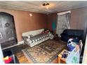 A small living room with hardwood floors, a couch and day bed in need of remodeling at 302 Melrose Sw Dr, Concord, NC 28025