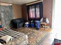 A small living room with hardwood floors, a couch and day bed in need of remodeling at 302 Melrose Sw Dr, Concord, NC 28025