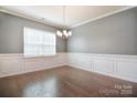 Formal dining room with chair rail, hardwood floors, a chandelier, and large windows at 3073 Oliver Stanley Trl, Lancaster, SC 29720