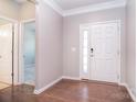Bright entryway featuring wood floors, a white front door, and a view into another room at 3073 Oliver Stanley Trl, Lancaster, SC 29720