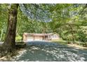 Charming home featuring a two-car garage, front porch, and a spacious driveway surrounded by mature trees at 3116 Old Montgomery Place Rd, Monroe, NC 28112