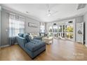 Bright living room featuring a comfortable blue sectional sofa, wood floors, and sliding doors to a screened porch at 31226 Cove View Ct, Lancaster, SC 29720