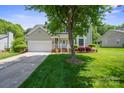 Well-maintained home with a two-car garage, lush lawn, and welcoming front entrance at 374 Queens Sw Dr, Concord, NC 28025