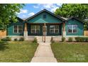 Beautifully renovated craftsman home with inviting front porch and manicured lawn at 6034 Tuckaseegee Rd, Charlotte, NC 28208