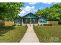 Charming craftsman home with a welcoming porch and lush green lawn at 6034 Tuckaseegee Rd, Charlotte, NC 28208