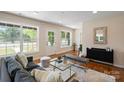 Bright living room featuring hardwood floors, large windows, and stylish contemporary furniture at 6034 Tuckaseegee Rd, Charlotte, NC 28208