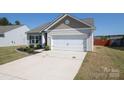 Well-kept one-story home with neutral siding, tidy front yard, and two-car garage in a suburban neighborhood at 6719 Jerimoth Dr, Charlotte, NC 28215