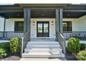 Inviting front porch with classic pillars, double doors, and manicured landscaping, creating a grand entrance at 1005 Grand Oak Dr, Waxhaw, NC 28173