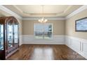 Elegant dining room showcasing wainscoting, hardwood floors, and a classic chandelier fixture at 1011 Potomac Rd, Indian Trail, NC 28079