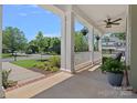 Relaxing front porch featuring a ceiling fan, hanging plants and a seating area at 1012 Sudbury Ln, Matthews, NC 28104