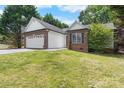 A single-story brick home featuring a well-manicured lawn and an attached two-car garage at 103 Pine Meadows Cir, Hickory, NC 28601