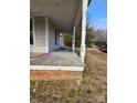 Inviting side porch with classic white columns and brick base, perfect for relaxing outdoors on a sunny day at 105 E Second Ave, Mount Gilead, NC 27306