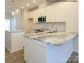 Bright kitchen with island, marble countertops, white cabinets, stainless appliances, and pendant lighting at 1116 Bismuth Way, Charlotte, NC 28211