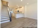 Open-concept living space featuring modern flooring, recessed lighting, and staircase leading to the next level at 1116 Bismuth Way, Charlotte, NC 28211