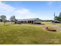 Expansive front lawn showcasing a well-maintained brick home and carport with a scenic view at 1160 Redmon Rd, Cleveland, NC 27013