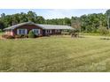 Brick home with a large front yard, beautiful landscaping, and mature trees at 1160 Redmon Rd, Cleveland, NC 27013